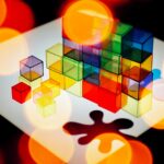 Colorful transparent cubes and abstract bokeh light create a vibrant geometric design.